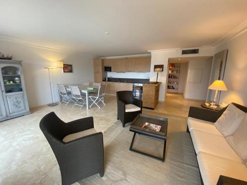 un salon avec un canapé, des chaises et une table dans l'établissement domaine de la baie, à Cavalaire-sur-Mer