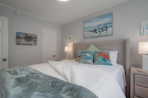 een slaapkamer met een bed met witte lakens en blauwe kussens bij 6700 Sunset Way Unit 702 in St Pete Beach