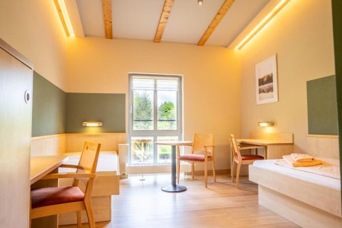a room with a bed and a table and chairs at Forum Grillensee in Naunhof