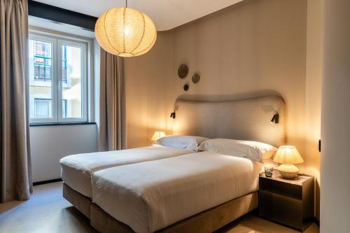 a bedroom with a large bed and a window at Casa Teva Lisboa Boutique Hotel by chic&basic in Lisbon