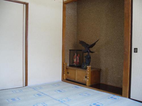 a bedroom with a bed and a bird statue on a dresser at Minshuku Mutsukari in Furano