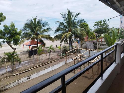 a balcony with a view of a beach and palm trees at RS Hotel Granada in Atacames