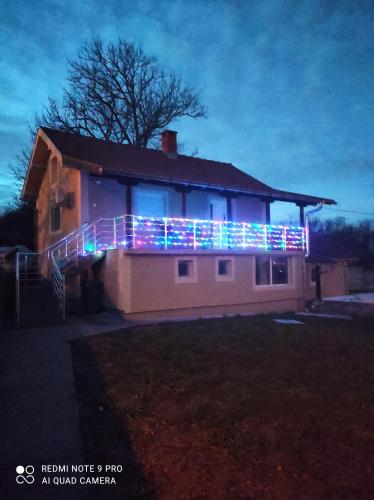 a house with christmas lights on the side of it at Apartman HILL 3 in Golubac