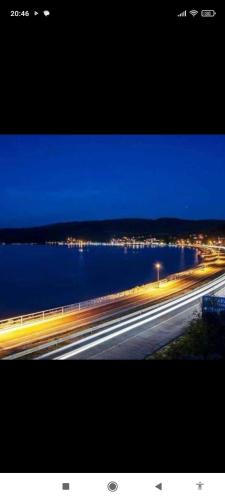 a view of a highway at night with water and lights at Apartman HILL 3 in Golubac