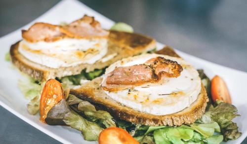 three sandwiches on a plate with lettuce and carrots at Hotel Le Bourgogne in Cuiseaux