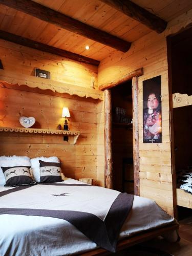 une chambre avec un lit dans une cabane en rondins dans l'établissement GITE COSY 