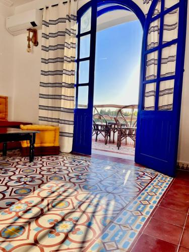 a room with a blue door and a patio at Dmina House in Asilah