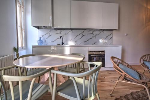 une cuisine avec une table et des chaises dans une pièce dans l'établissement Petit cocon en cœur de ville, à Arcachon