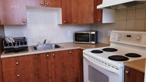 a kitchen with a white stove and a microwave at Cozy Suite #1 in the Heart of DT Quebec with QB in Quebec City