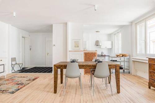 une cuisine et une salle à manger avec une table et des chaises en bois dans l'établissement Adriana - 120m hypercentre tram 1 ch, à Saint-Étienne