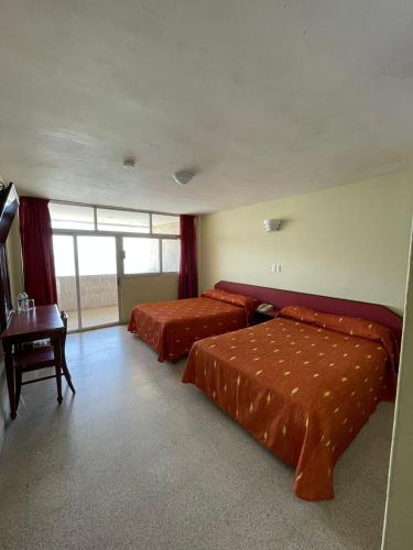 a hotel room with two beds and a table at Hotel Royalty in Veracruz