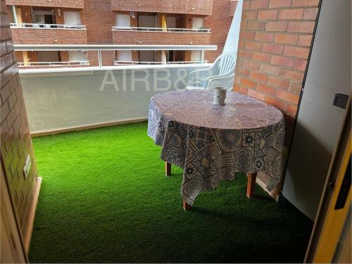 a table on a balcony with green grass at Apartamento Oropesa primera línea Acapulco III in Oropesa del Mar