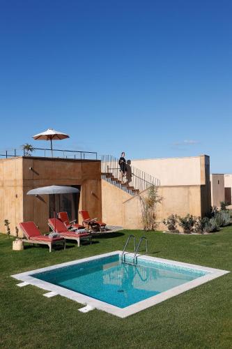 a swimming pool in the yard of a house at Praia do Canal Nature Retreat - Small Luxury Hotels of the World in Aljezur