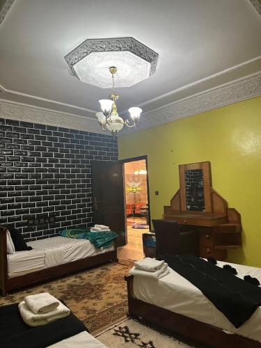 a living room with two beds and a piano at Riad Dar Fadma in Ouarzazate