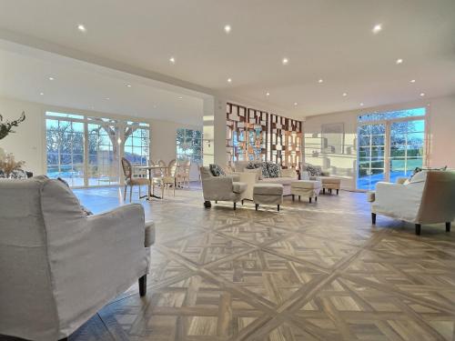 a lobby with white chairs and tables and windows at Domaine de Bonaveau - Spa & Piscine in Barcelonne
