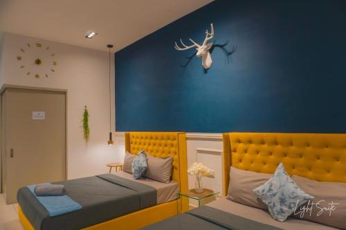 a bedroom with two beds and a blue wall at Cozy Room 5min From Airport Wi-fi & Netflix At Aeropod Sovo in Kota Kinabalu
