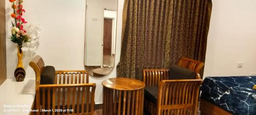 a room with a table and chairs and a mirror at Raja Hill Resorts in Kodaikānāl