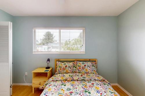 a bedroom with a bed and a window at Wavesong Refuge in McKinleyville