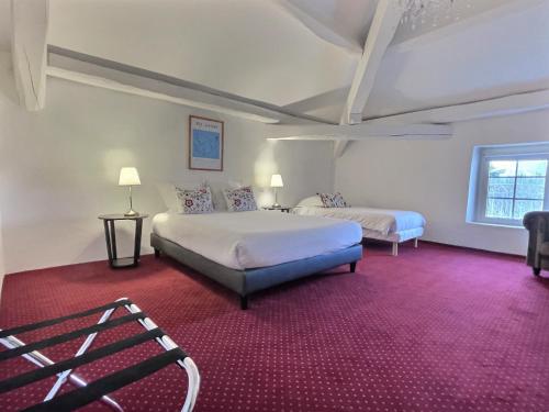a bedroom with two beds and a red carpet at Domaine de Bonaveau - Spa & Piscine in Barcelonne