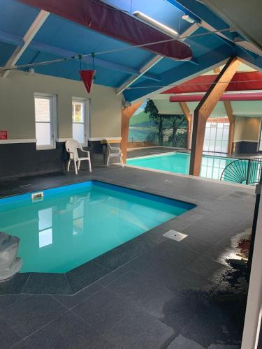 a large swimming pool in a building with a blue ceiling at Voorts Broekhuisje 5 in Voorthuizen
