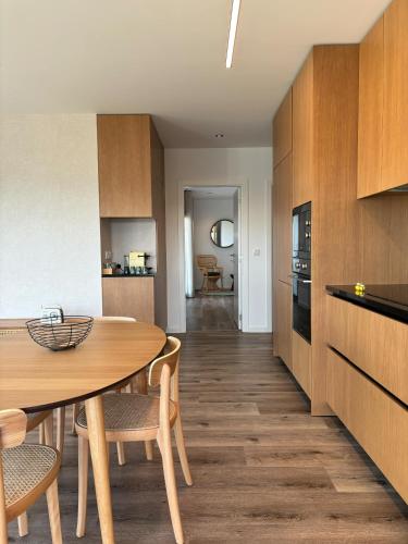 a kitchen with a table and chairs in a room at Afrodite Styling Penthouse in Nazaré