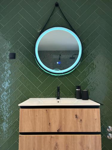 a bathroom with a mirror and a sink at Afrodite Styling Penthouse in Nazaré