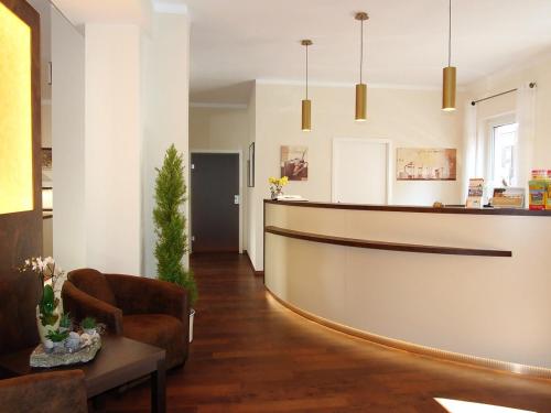a lobby with a reception desk and a chair at Altstadthotel Goldene Kugel in Waren