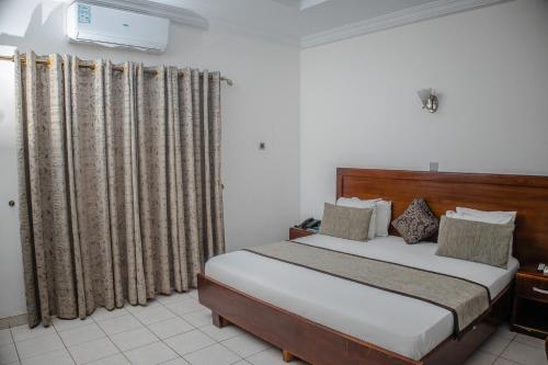 a bedroom with a bed and curtains in it at Stadium Hotel in Kumasi