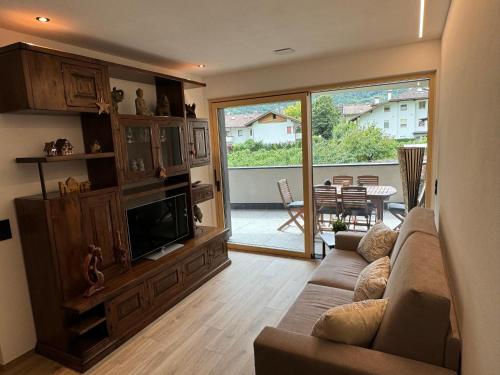 a living room with a couch and a tv at Renesmee Apartment in Naturno