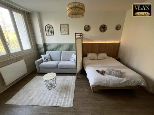 a small bedroom with a bed and a couch at En bord de Sèvre in Niort