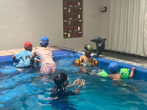 a group of children in the water with a dolphin at Jacob Farms in Denkanikottai