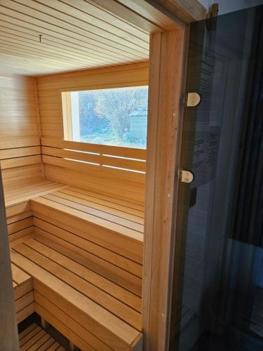 a small wooden sauna with a window in it at Honey Spa house in Novi Slankamen