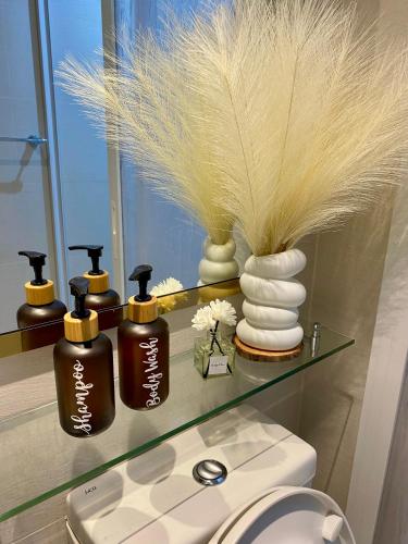 a bathroom with a shelf with four bottles of soap at Azure Staycation PH 1503 in Manila