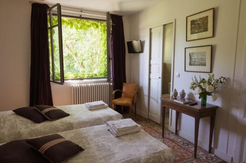 a hotel room with two beds and a window at La Foutelaie in Clefs-Val d'Anjou