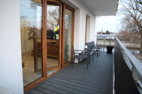 a balcony with chairs and windows on a building at Wenus Apartament in Pisz