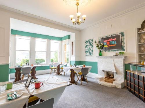 a dining room with tables and a fireplace at Norbury House Stylish Accommodation in Ilfracombe