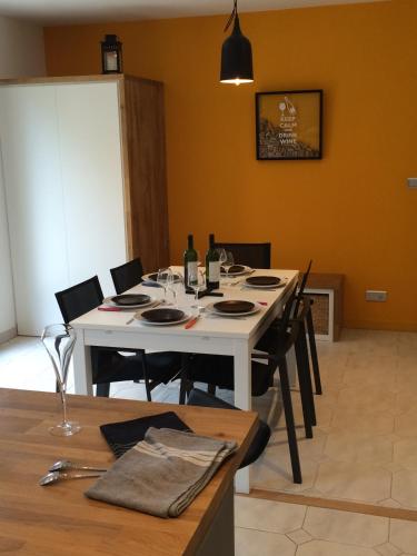 a dining room with a white table and chairs at Château la Renommée in Saint-Laurent-des-Combes