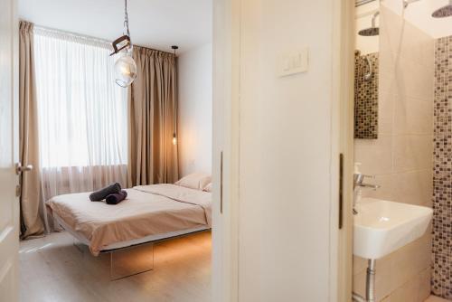a bedroom with a bed and a bathroom with a sink at Heart of Old Town in Bucharest