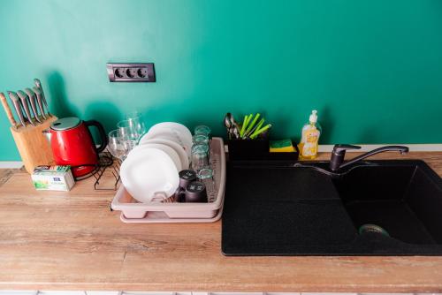 a kitchen sink with dishes in a dish rack next to it at Heart of Old Town in Bucharest