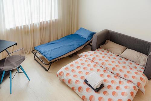 a bedroom with two beds and a table and a desk at Heart of Old Town in Bucharest