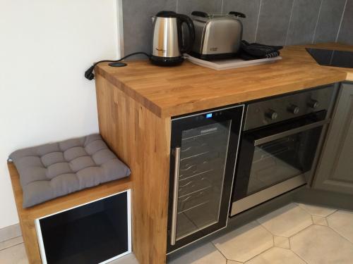 a kitchen with a wooden counter top with a microwave at Château la Renommée in Saint-Laurent-des-Combes