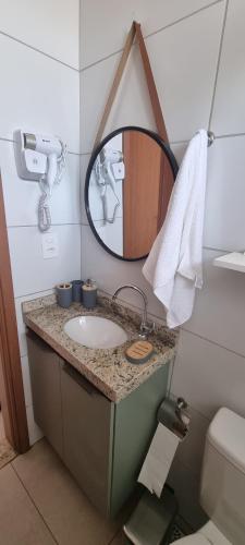 a bathroom with a sink and a mirror at Apartamento aconchego Atalaia in Luis Correia