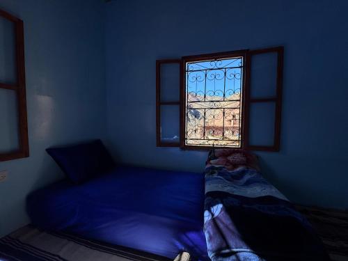 a blue room with a bed and a window at Gite Megdaz in Megdaz