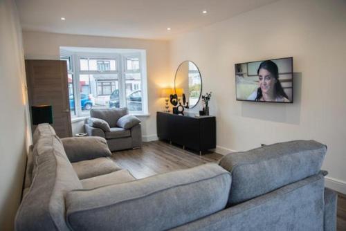 a living room with a couch and a tv at Luxury Modern 3 Bedroom House in Bridgend