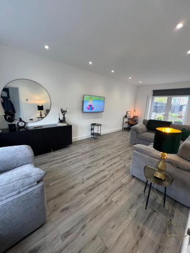 a living room with two couches and a tv at Luxury Modern 3 Bedroom House in Bridgend