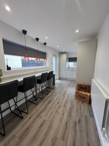 an empty room with a bar with chairs in it at Luxury Modern 3 Bedroom House in Bridgend