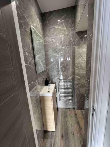 a bathroom with a sink and a mirror at Luxury Modern 3 Bedroom House in Bridgend