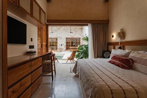 una camera da letto con un letto, una scrivania e una televisione di Casa La Piedra a Mérida