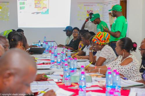 a group of people sitting around a long table at Stadium Hotel in Kumasi