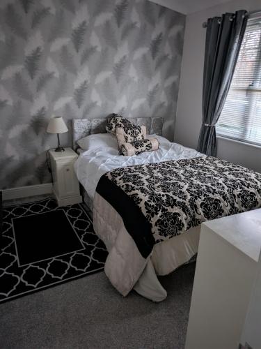 a bedroom with a bed with a black and white comforter at Unique 2 bed lodge lyons Robinhood in Rhyl
